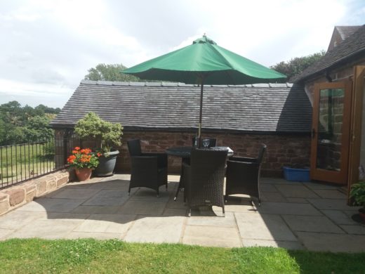 Outside garden area with table, chairs & sun umbrella